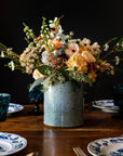 Floral arrangement in a textured ice-blue Frost glaze on a wooden table with a dark background