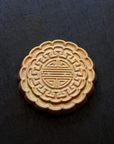 A Mooncake Paperweight in shimmering Blush Iridescent.