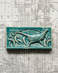 This hand-sculpted tile features a pheasant running through a field of dandelions. It is featured in a glossy blue Glacier glaze.