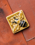 A glossy hand-painted Honeybee Tile in golden honey and black details.