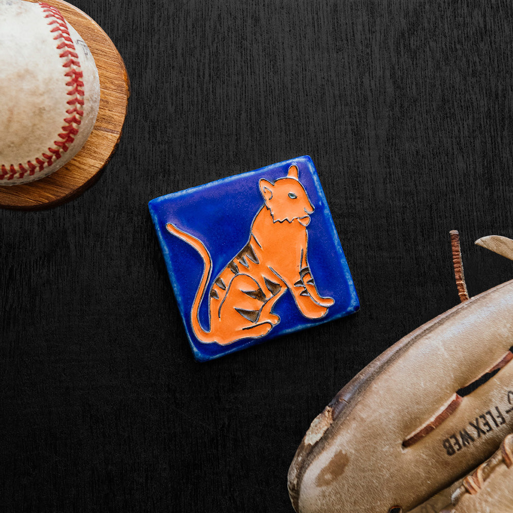 Hand-painted 3x3 Tigers tile on a dark wood surface with a baseball and glove.
