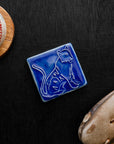 Glossy blue 3x3 Tigers Tile on a black wood background with a baseball and glove.