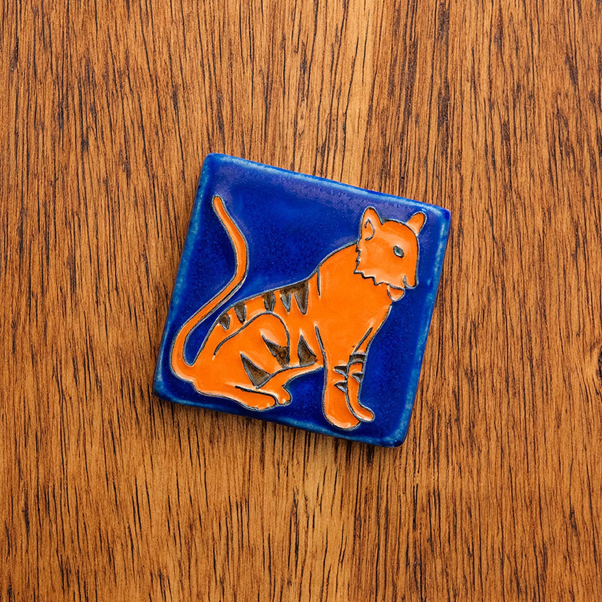 Hand-painted 3x3 Tigers tile on a wooden surface. 