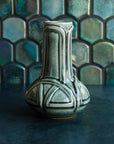 A glossy green Balsam Celtic Vase against an Iridescent fishscale tile background.