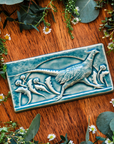 This hand-sculpted tile features a pheasant running through a field of dandelions. It is featured in a glossy blue Glacier glaze. 