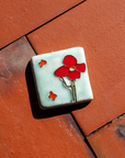 The Cactus Flower Tile features a large, four petalled flower on a thicker cactus stem. Two small petals seem to fly in the wind next to it.