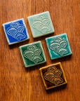 All four glaze types are represented in this image. Celadon, Pewabic Blue, Periwinkle, Molasses, and Emerald.