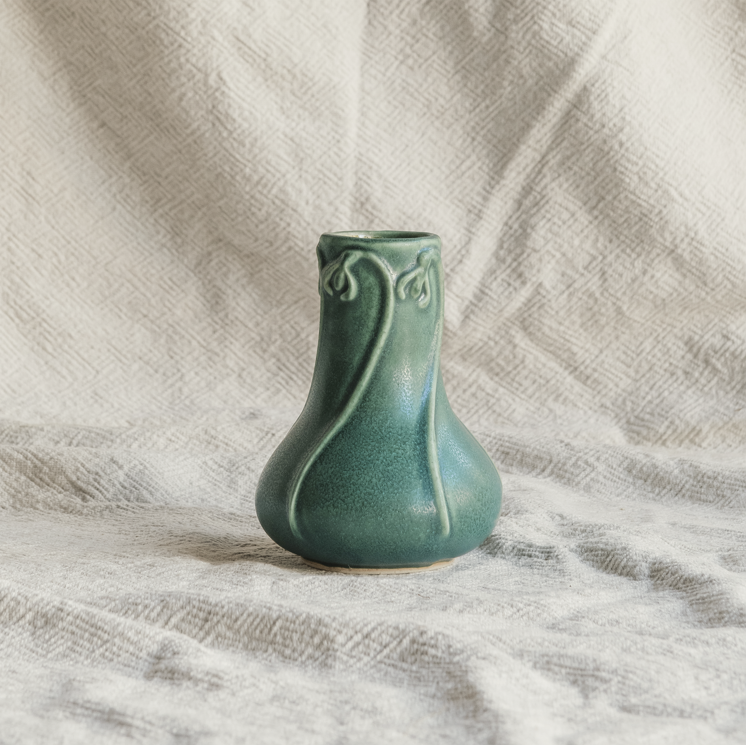 Elm-glaze Snowdrop vase on a natural canvas material in off-white.