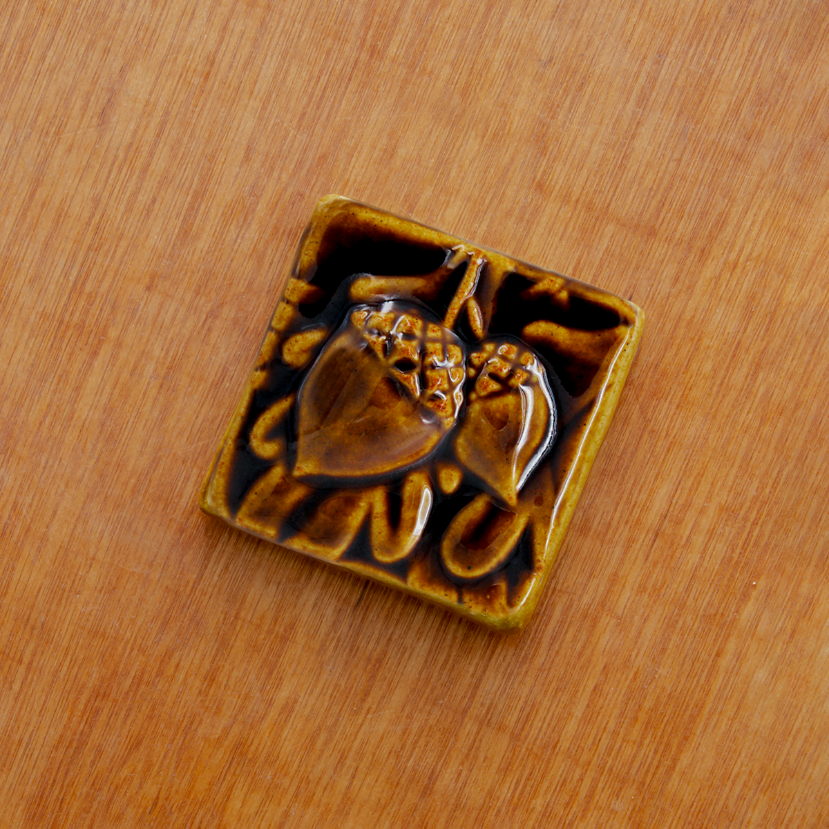 This 3x3 ceramic acorn tile is in the glossy deep brown Molasses glaze option.