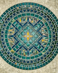 An aerial view of a custom, circular, tile medallion with elements of a classic compass. The design incorporates glossy, matte, and iridescent glazes in an intricate geometric pattern.  