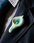 Ceramic Calla Lily Pin in pale glossy blue glaze used as a boutonniere on a suit lapel.
