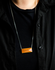 The necklace is shown at its longest, with the tile reaching down past the wearer's breastbone. 