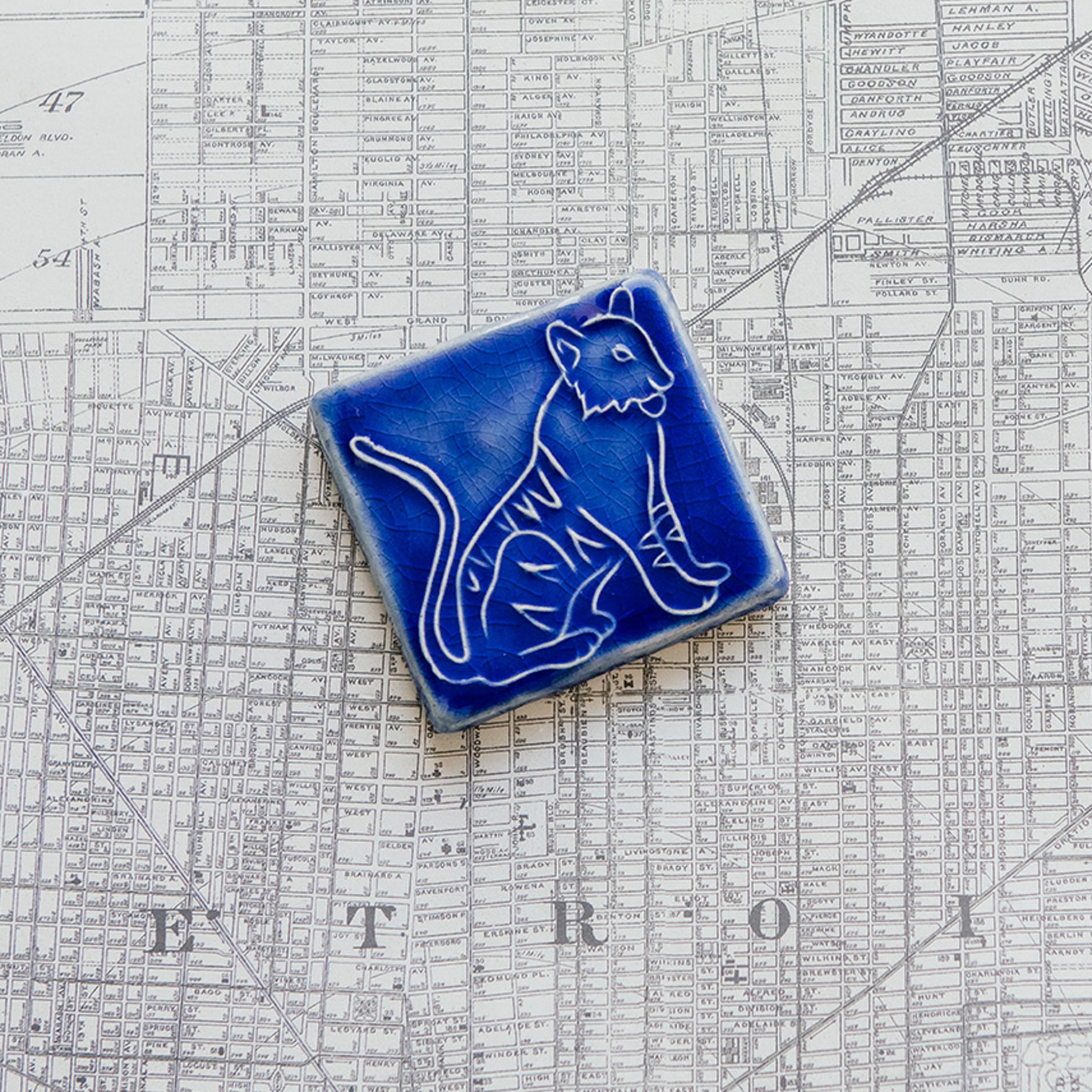 Glossy blue 3x3 Tigers Tile on a map of Detroit.
