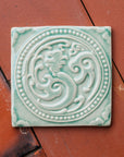 This celadon Phoenix rests on terracotta roof tiles.