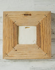 The back of the framed piece shows the open-back structure of the frame. This exposes the Pewabic Stamp on the back of the tile.