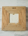 The back of the framed piece shows the open-back structure of the frame. This exposes the Pewabic Stamp one the back of the tile.