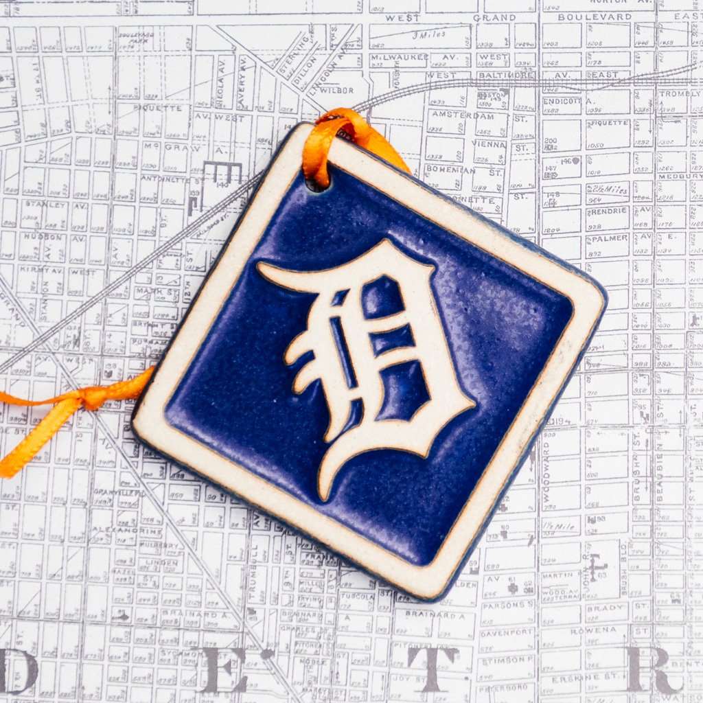 The Navy/Natural color option includes a dark blue background and a scraped cream colored logo and border.