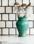 The Small Classic Vase starts with a small diameter at its base that gradually gets larger until it contracts again near the top with a slightly wider lip. The sides of the vase have been swiped with slip, this gives the appearance of abstract petals overlapping on the widest part of the vase.